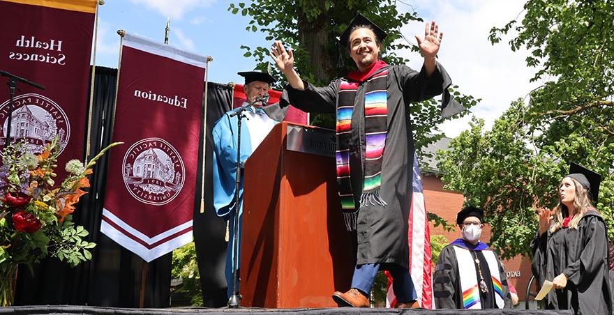 A happy male student crosses the stage at Seattle Pacific University